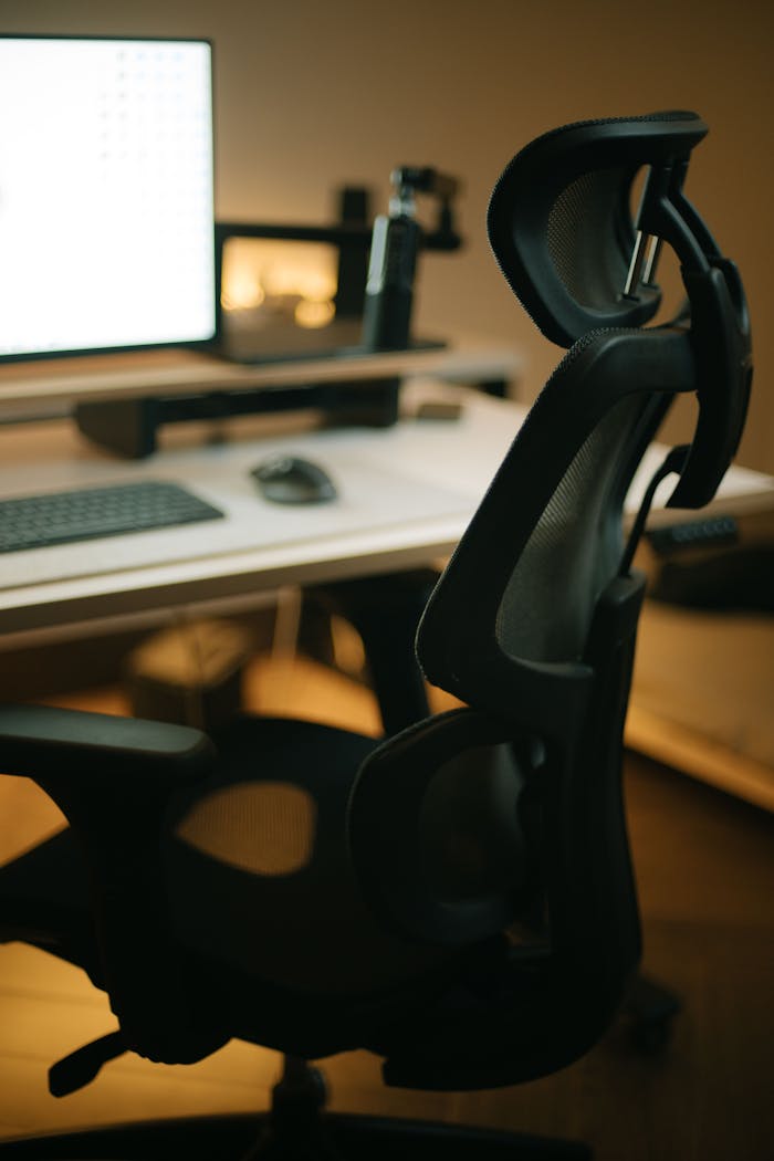 A sleek ergonomic chair and desk with computer setup, highlighting a modern workspace.